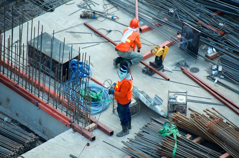Construction workers reviewing rebar layout on a commercial building foundation slab