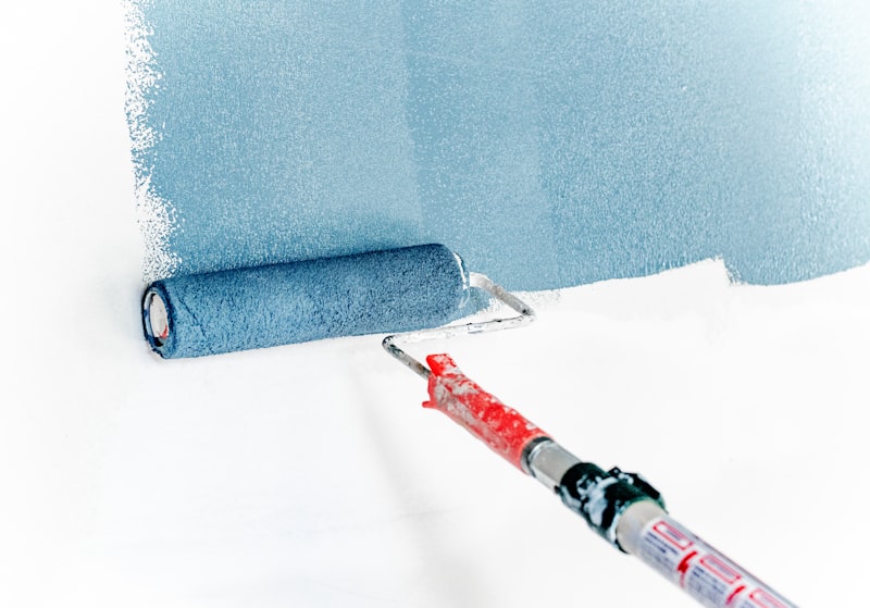 Paint roller applying finish coat to interior wall during commercial maintenance and decoration