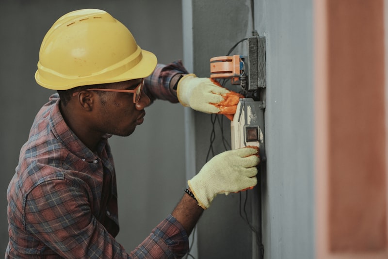 Electrician in hard hat and safety glasses working on a commercial electrical installation